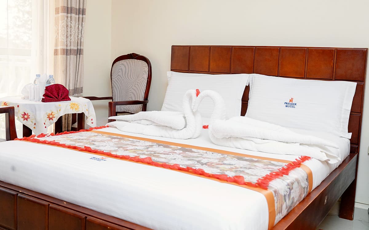 The executive room bed, made up with a runner and towel swans