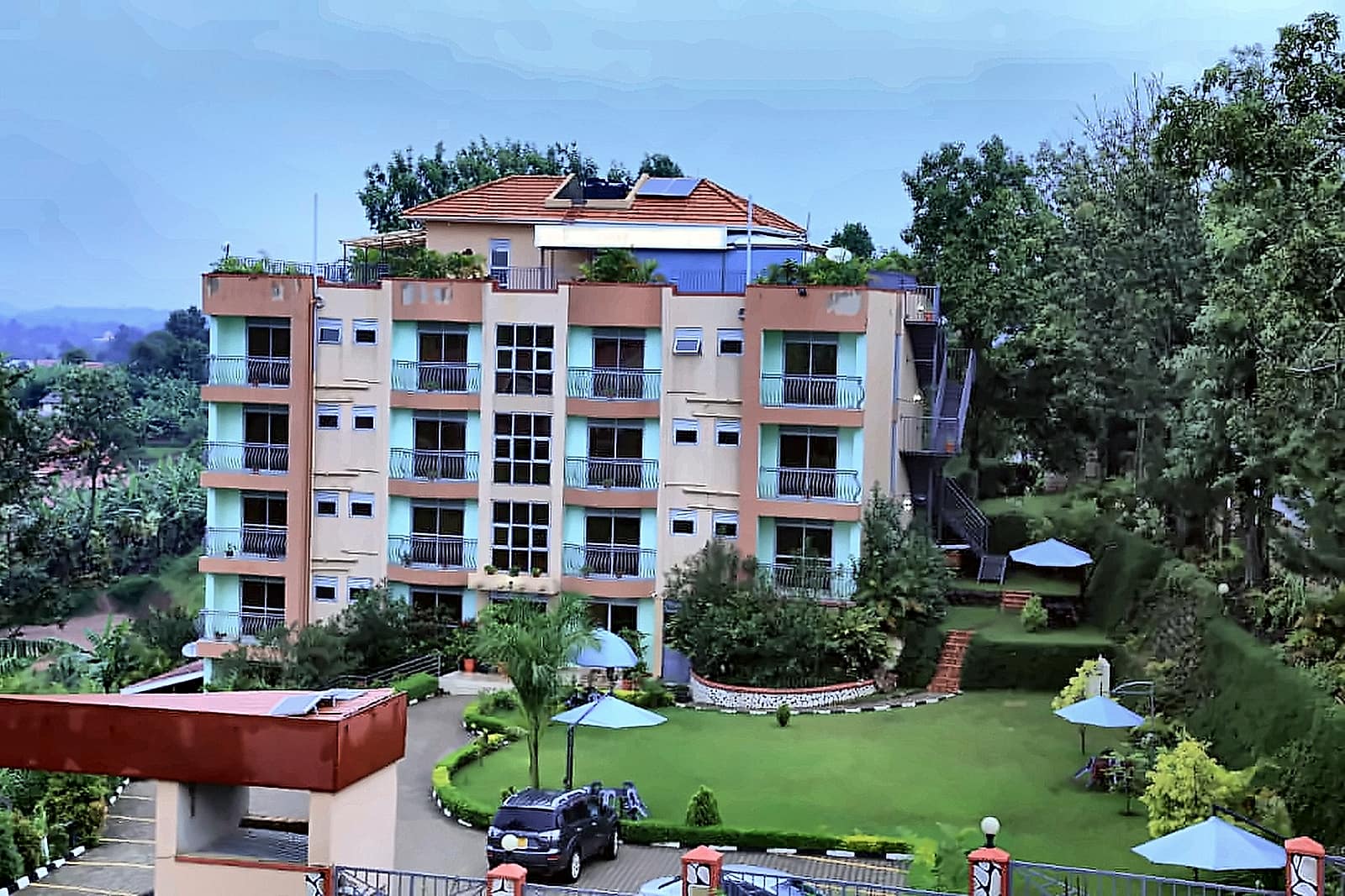 Hotel Premier rising behind its lawn and gardens in Bushenyi
