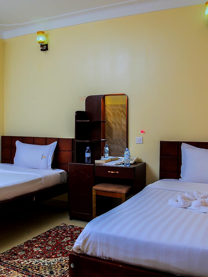 A twin room with two made beds