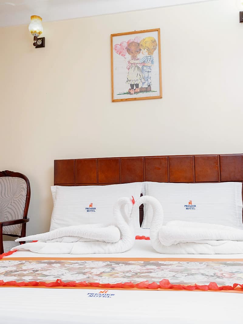 Towels folded into swans on a turned-down bed